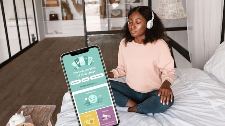 Frau atmet nach einer App sitzend auf dem Bett